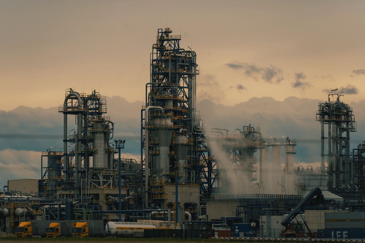A detailed view of a refinery's towers against a cloudy dusk sky, showcasing industrial architecture.